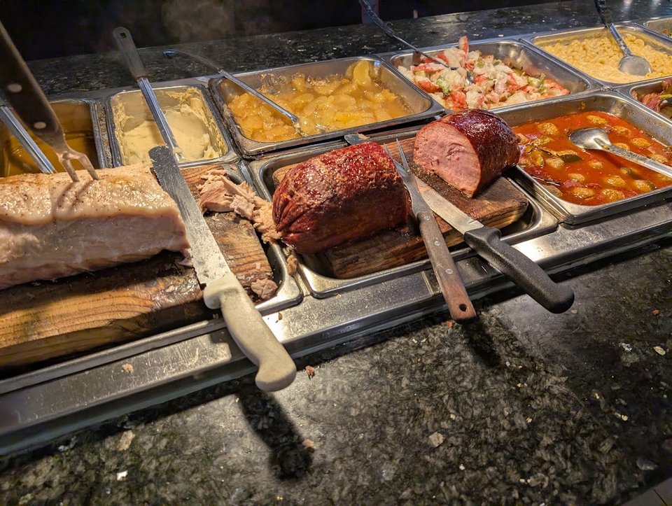 Rows of hot food under bright lights.